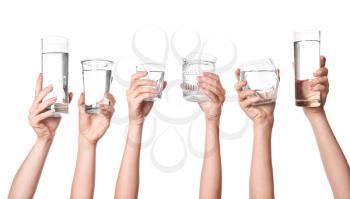 Female hands with glasses of water on white background�