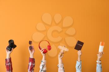 Many hands with travel items on color background�