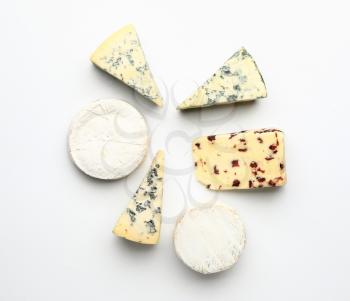 Assortment of fresh cheeses on white background�