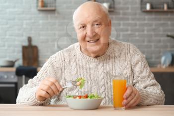 Portrait of elderly man having lunch at home�