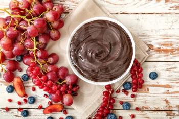 Bowl with tasty chocolate fondue and berries on table�