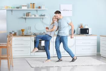 Happy dancing young couple in kitchen�