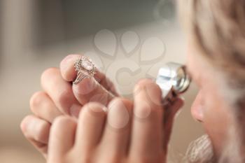 Jeweler examining ring in workshop, closeup�
