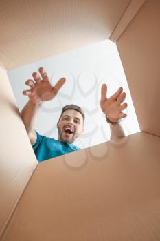 Happy man with open box, view from inside�