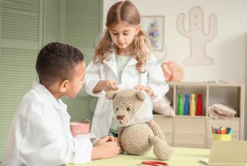 Cute little children dressed as doctors playing at home�