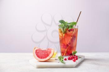 Glass of cold tea on light background�
