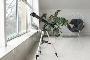 Modern telescope in interior of room�