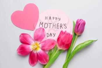 Beautiful flowers and card for Mother's Day on white background�