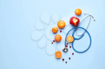 Healthy products and stethoscope on color background�