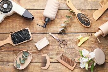Set of hairdresser's accessories on wooden background�