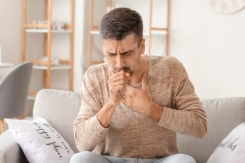 Coughing young man at home�