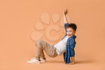 Cute little boy dancing against color background�