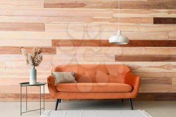 Sofa and table near wooden wall�