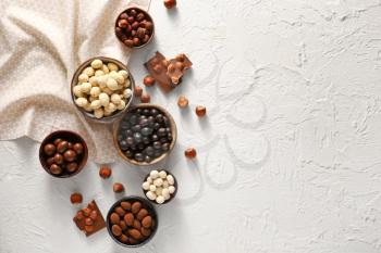 Different tasty chocolate nuts on white background�