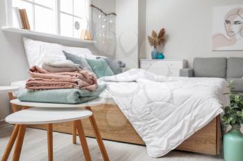 Soft plaids on table near bed in room�