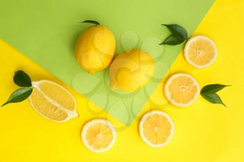Flat lay composition with ripe juicy lemons on color background�