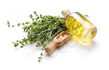 Bottle of essential oil with pills and thyme on white background�