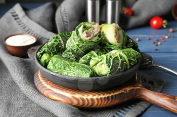 Pan with stuffed cabbage leaves on wooden board�