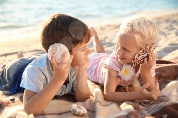 Cute little children with sea shells on beach�