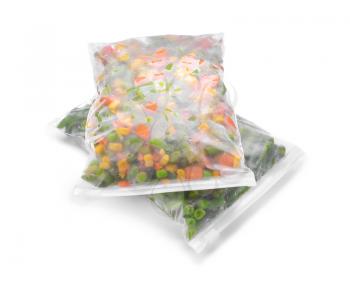 Plastic bags with frozen vegetables on white background�