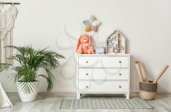 Chest of drawers with clothes and toys in children's room�