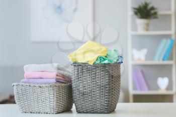 Baskets with laundry on table in room�