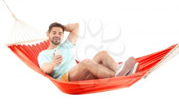 Young man with mobile phone relaxing in hammock against white background�
