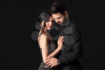 Young couple wearing stylish accessories on dark background�