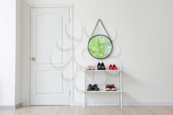 Stylish interior of modern hall with shoes on stand�