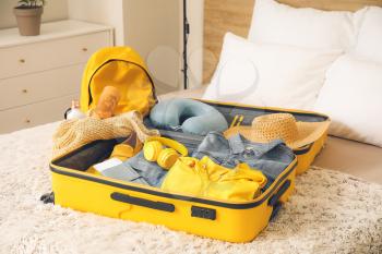Packed suitcase on bed. Travel concept�