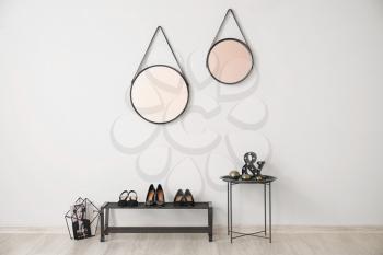 Stylish interior of modern hall with shoe stand, table and mirrors�