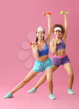 Young women doing aerobics on color background�