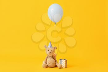 Air balloon with teddy bear and gift on color background�