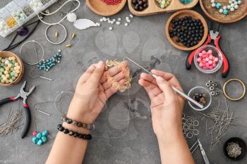 Female designer making jewelry, top view�