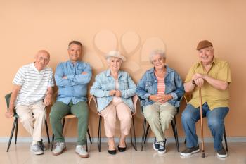 Senior people sitting on chairs in room�