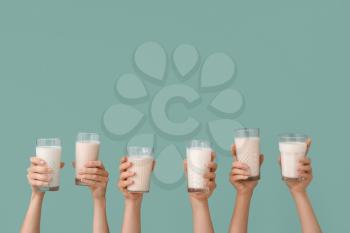 Female hands with glasses of vegan milk on color background�