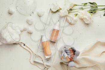 Bottles of makeup foundation and accessories on light background�