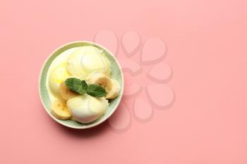 Bowl with banana ice-cream and mint on color background�