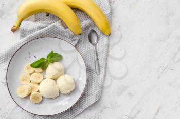 Plate with tasty ice cream and bananas on light background�