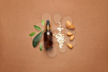 Composition with bottle of natural cosmetic oil on color background�