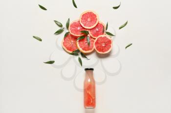 Creative composition with bottle of juice and ripe grapefruits on white background�