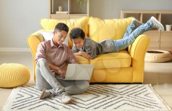 African-American boys using laptop at home�