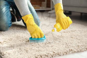 Mature man cleaning carpet at home, closeup�