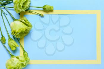 Beautiful flowers and blank frame on color background�