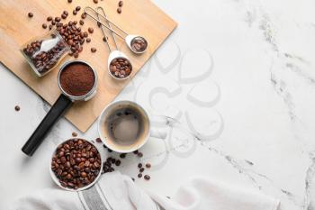 Composition with cup of coffee, beans and powder on light background�