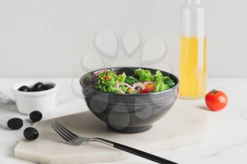 Bowl of fresh salad with vegetables on light background�