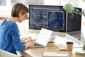 Female programmer working with laptop in office�