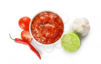 Bowl of tasty salsa sauce and ingredients on white background�