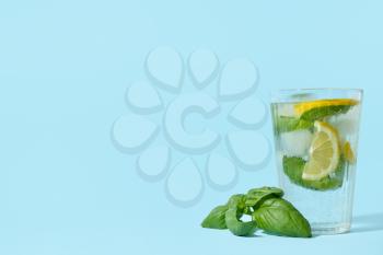 Glass of tasty lemonade with basil on background�