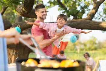 Happy family at barbecue party on summer day 